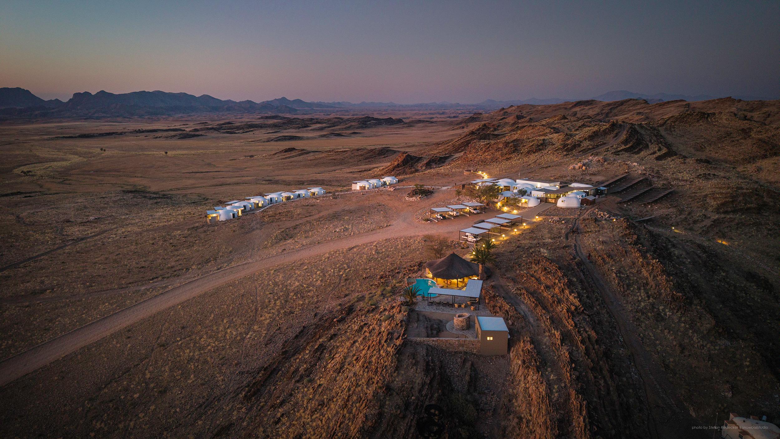 Vast Namib Desert landscape at golden hour with dramatic red sand dunes and endless horizon